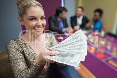 Woman holding out fan of dollars
