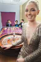 Woman smiling beside roulette wheel