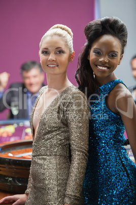 Two women standing beside roulette table