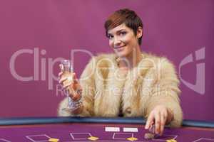 Woman with champagne at poker table