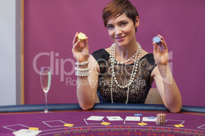 Woman at poker game holding up chips