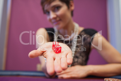 Woman holding dices at table