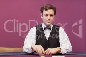 Dealer sitting in a casino distributing chips