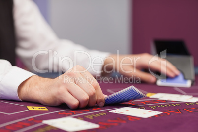 Dealer distributing cards in a casino