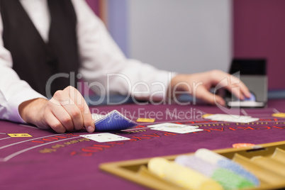 Dealer distributing cards at table