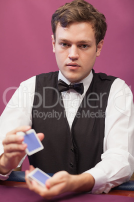 Dealer sitting in a casino while shuffling cards