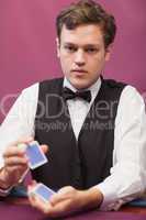 Dealer sitting in a casino while shuffling cards