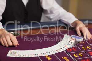 Dealer dealing out cards at roulette table