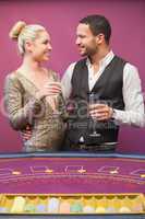 Couple drinking champagne at poker table