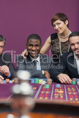 Three men and a woman at roulette table