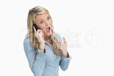 Woman looking shocked on the phone