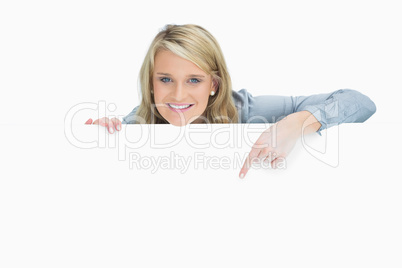 Cheerful woman pointing down