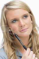 Blonde holding a pen while thinking