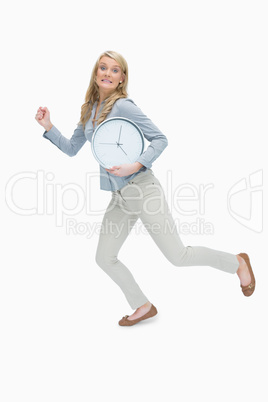 Woman running while holding a clock