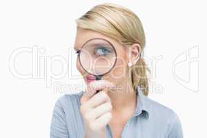 Businesswoman looking through magnifying glass