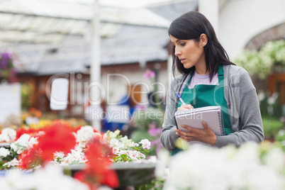 Worker taking notes while choosing a flower