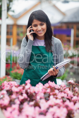 Black-haired woman calling while doing stocktaking