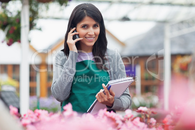 Employee talking on phone while checking flowers