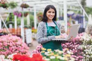 Woman using laptop in the garden center