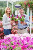 Couple holding purple plants and smiling