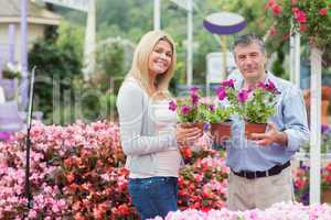 Couple holding flowers in garden center