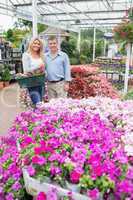 Couple standing in the garden centre and holding a basket