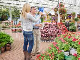 Couple searching for plants in garden centre