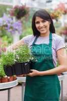 Smiling assistant carrying flower boxes