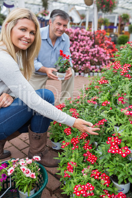 Couple crouching to look at flowers