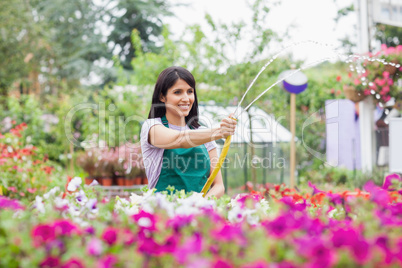 Employee watering plants with hose