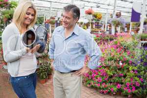 Couple smiling and looking at boot shaped flower pot