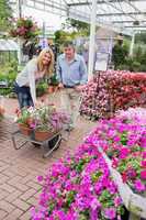 Smiling couple putting flowers in trolley