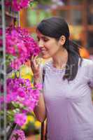 Woman smelling flowers in garden center