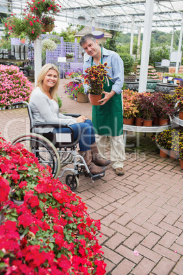 Smiling woman in wheelchair buying a flower