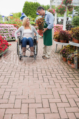 Woman in wheelchair buying potted plant