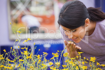 Woman smelling yellow flowers happily