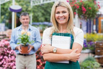 Woman holding a notepad with customer holding potted plant