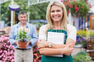 Woman holding a notepad with customer holding potted plant