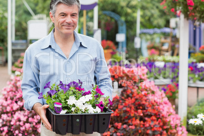 Man carrying boxes outside in garden center