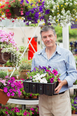 Smiling customer taking flower boxes outside