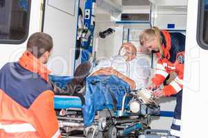 Paramedics putting patient in ambulance car aid