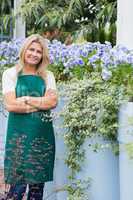 Happy employee beside purple flowers