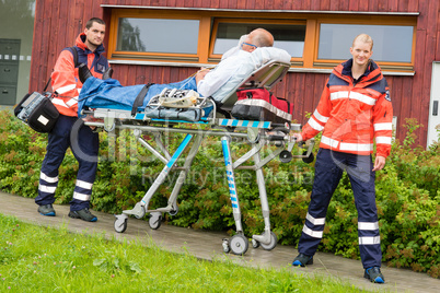 Paramedics with patient on stretcher ambulance aid
