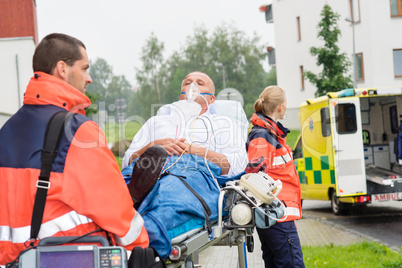 Paramedics with patient on stretcher ambulance aid