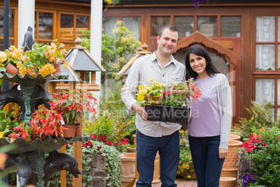 Couple carrying tray of plants