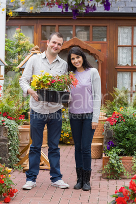 Smiling couple holding tray of plants