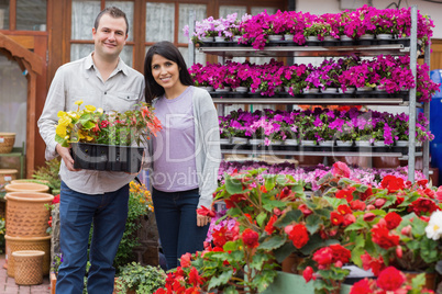 Happy couple holding tray of plants