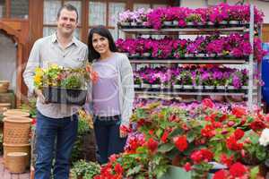 Happy couple holding tray of plants