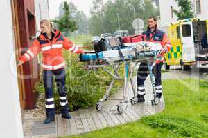 Paramedics carrying stretcher ambulance house call