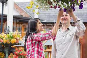 Couple touching flowers in hanging basket